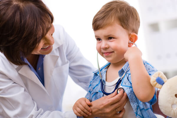 A Child with a doctor hearing his heartbeat