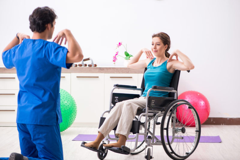 a nurse helping a women in exercising