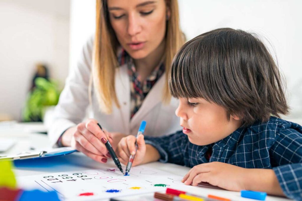 teacher teaching small boy