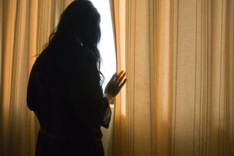 a woman standing at window