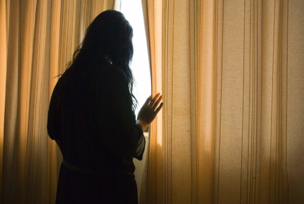 a woman standing at window