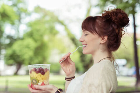 A Women eating fruit salad