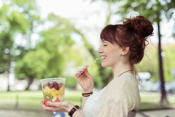 A Women eating fruit salad