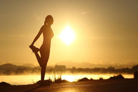 a woman exercising during the sunrise