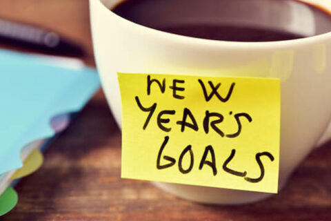 Coffee Cup with a new year goals sticky note