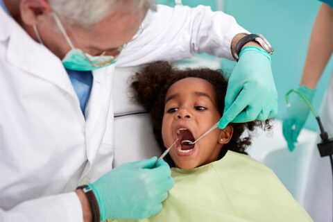 A doctor checking a teeth of a girl