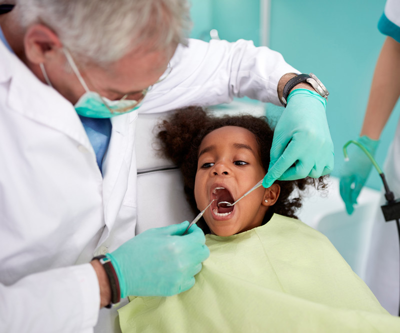 A doctor checking a teeth of a girl