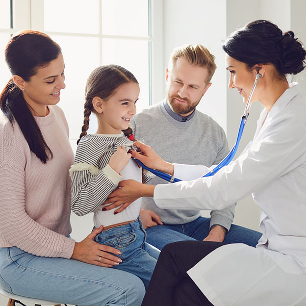 Happy family on a visit to the doctor in the office of a doctor