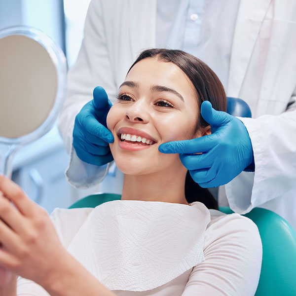 Shot of a young woman checking her results in the dentists office