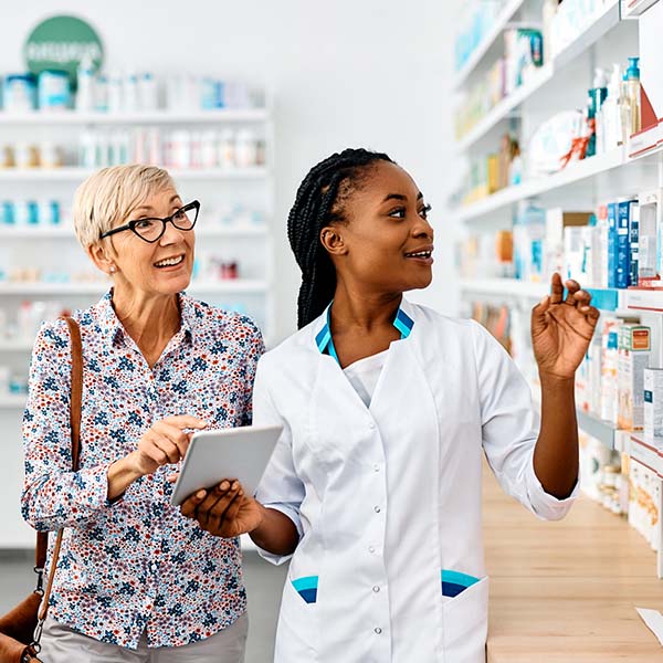 Happy senior woman buying prescription medicine in a pharmacy