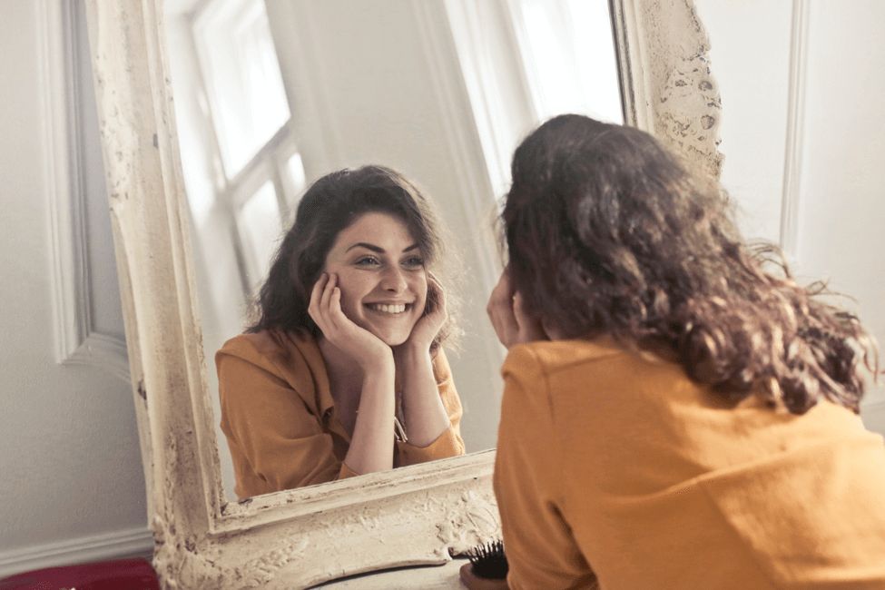 Women Smiling infront of Mirror