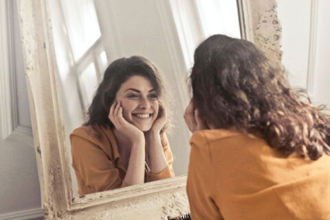 Women Smiling infront of Mirror
