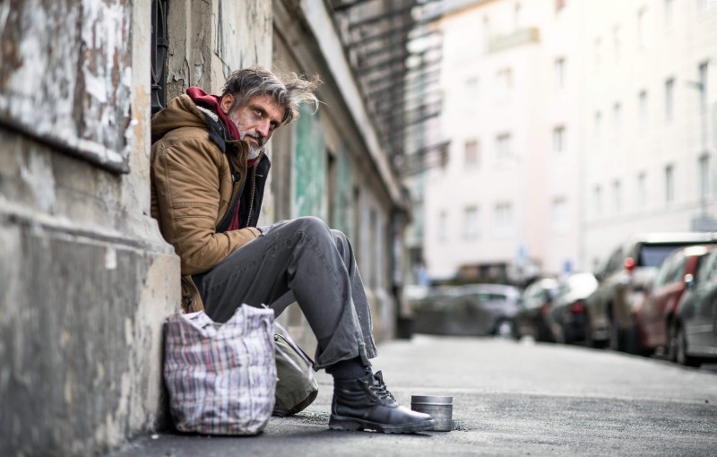 Homeless begger man sitting outdoors