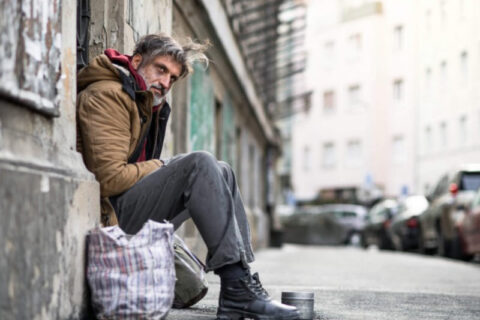 Homeless begger man sitting outdoors