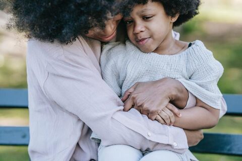 women hugging a kid