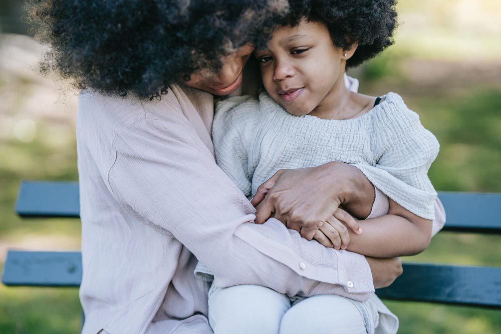 women hugging a kid