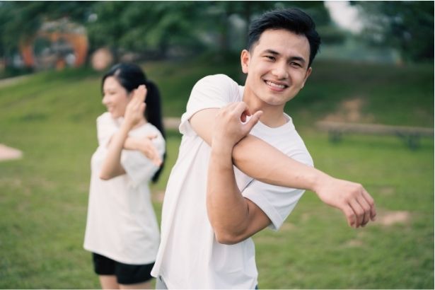 two young people stretching their arms