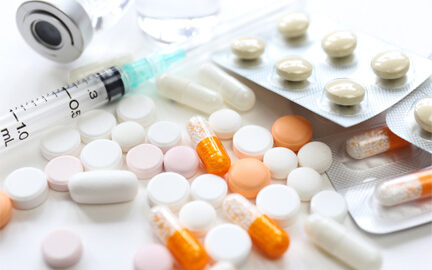 A collection of medicines in different forms including a syringe, tablet and caplet style pills