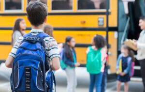 Anxious Little Boy going towards school bus 