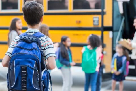 Anxious Little Boy going towards school bus