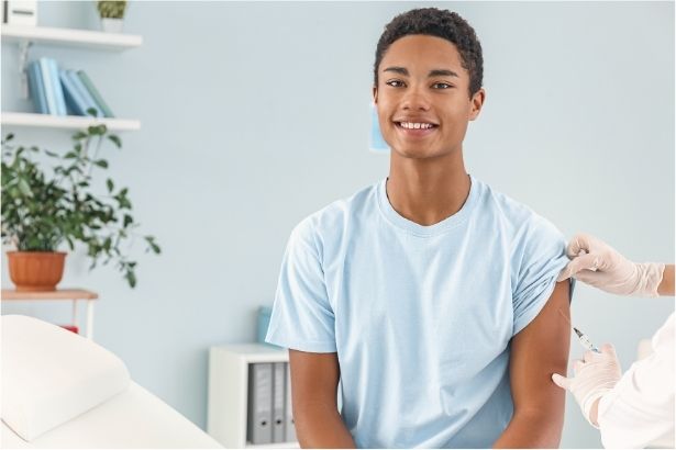 A boy in a doctor's office receiving a HPV vaccine