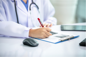 A physician making notes on a clip board