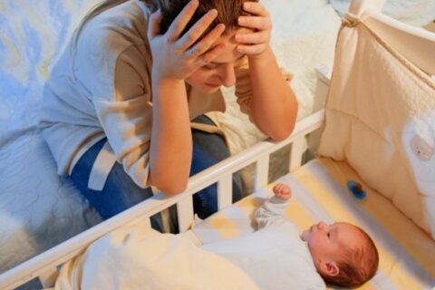 Woman looking worried while watching her newborn