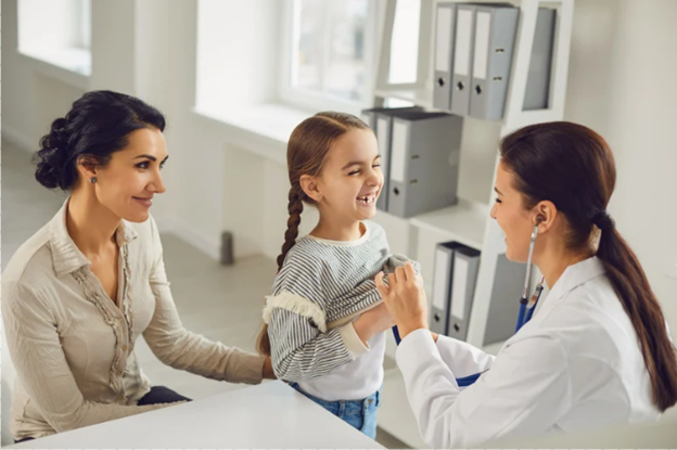 Pediatrician with young patient and mother