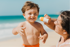 A mother applying sunscreen to a toddler's skin