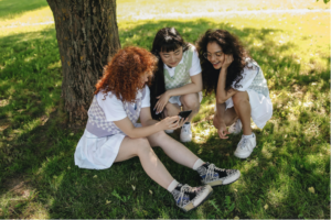 Teen aged girls sitting in the shade of a tree