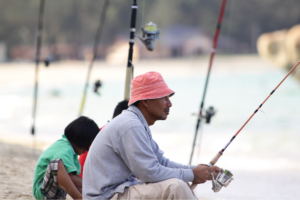 Man fishing in bucket hat, sunglasses, and long sleeve shirt