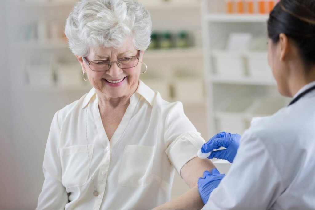 An elderly woman being prepared for a flu shot