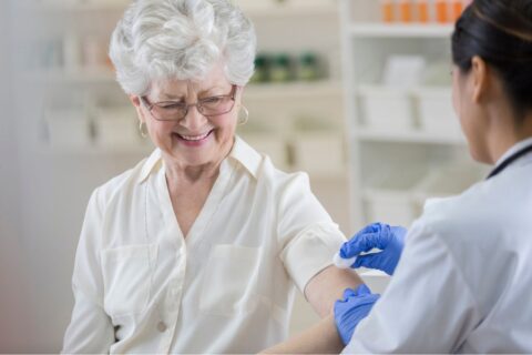 An elderly woman being prepared for a flu shot