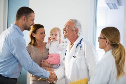 Family shaking pediatrician's hand