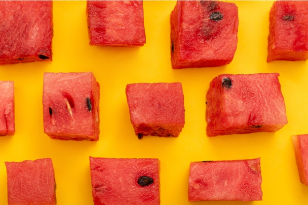 Watermelon cubes on bright yellow backdrop showcase vibrant colors in Brevard County, FL