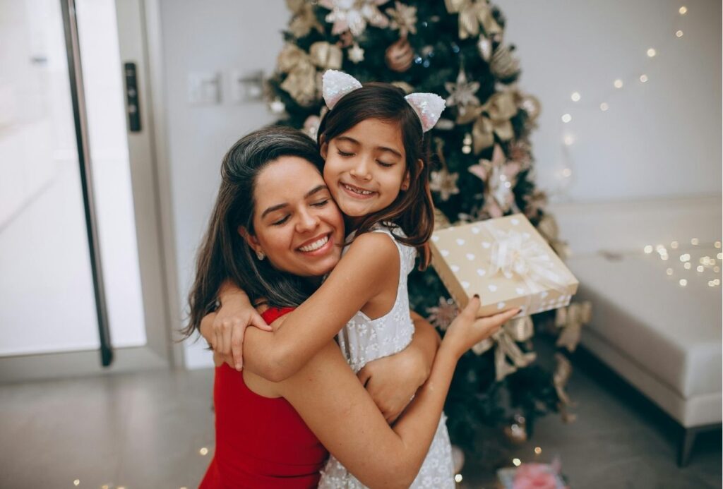 Woman and young girl hugging after exchanging presents