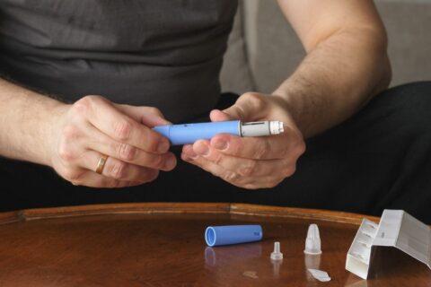 man holding insulin injector
