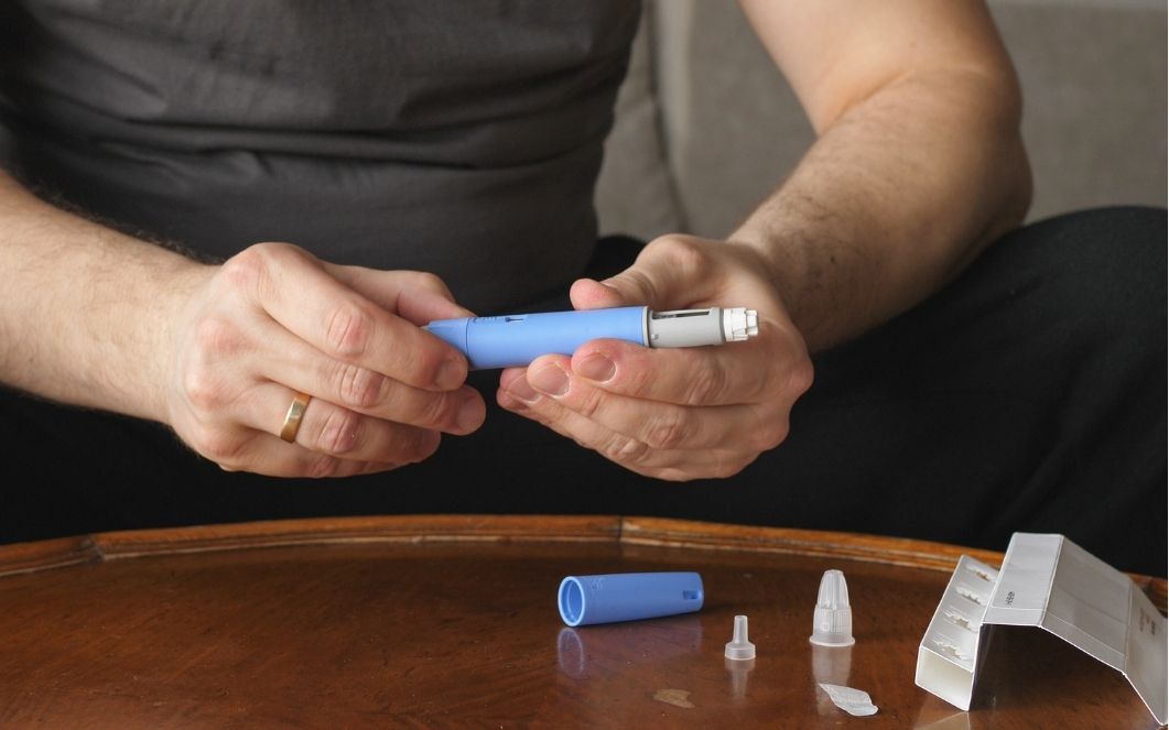 man holding insulin injector