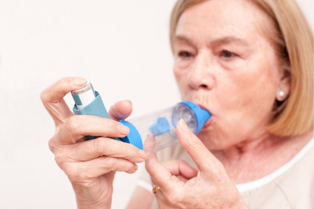 Patient Taking Asthma Inhaler in Front of Doctor- Brevard Health Alliance