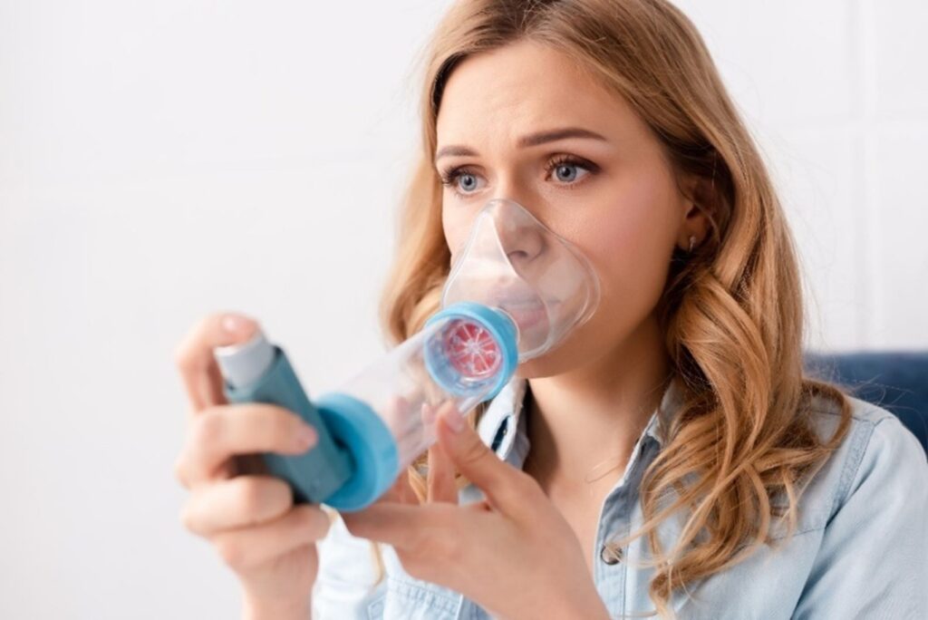 Person with a severe Asthma attack taking inhaler- Brevard Health Alliance